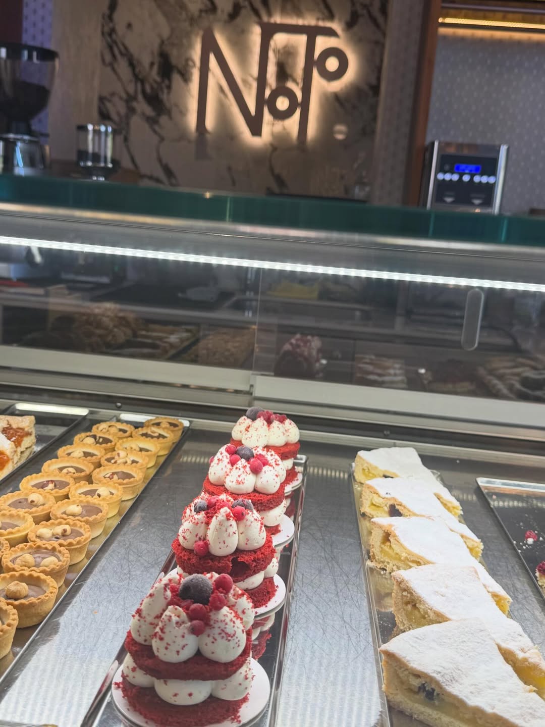 La vetrina dei dolci con l'insegna Noto illuminata sullo sfondo